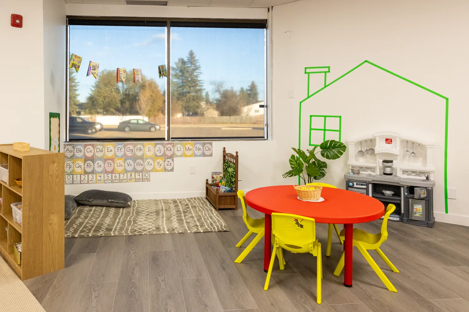 A dramatic play corner with a house drawn on the window
